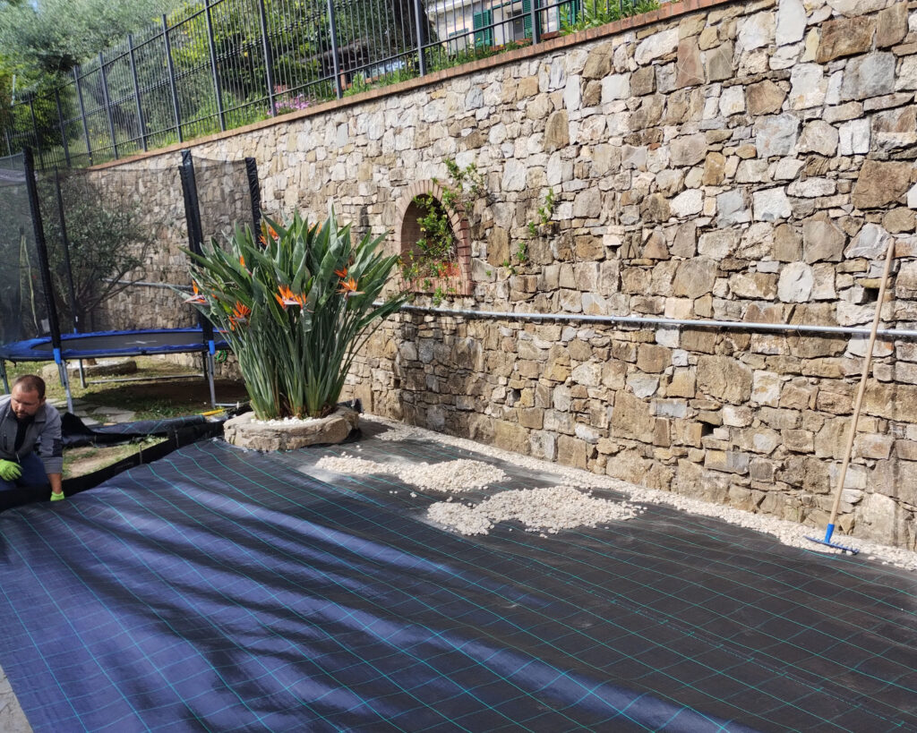 Piante esotiche e ghiaia in cortile con telo